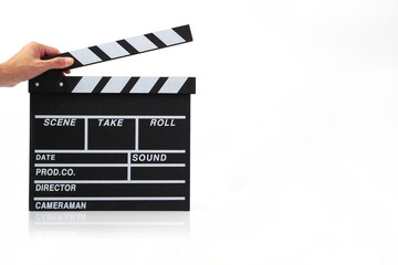 Fototapeta premium Hand holding a clapperboard or movie slate black color on white background. Cinema industry, video production and film concept..
