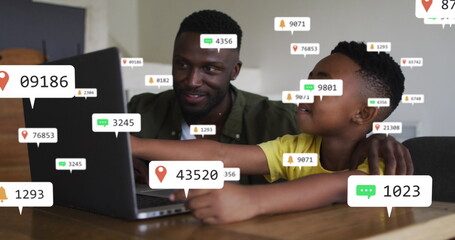 Image of media icons over african american father with son using laptop
