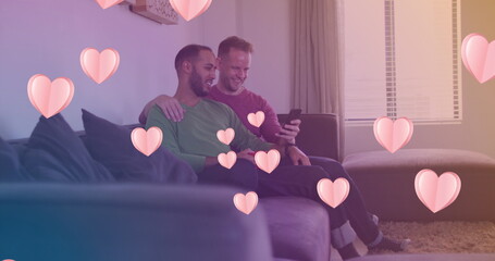 Image of heart icons over happy diverse gay couple embracing