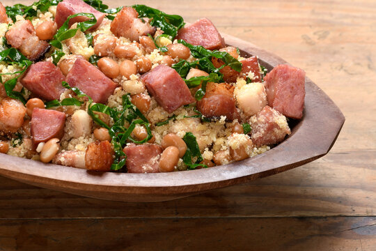 Feij&atilde;o tropeiro in a wooden container, typical food from Minas Gerais, Brazil, wooden base 
