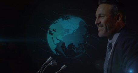 Image of globe spinning over caucasian businessman giving speech