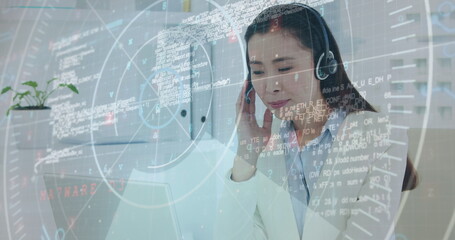 Image of data processing over asian businesswoman wearing phone headset using laptop at office