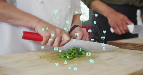 Image of network of connections with icons over diverse people chopping vegetables