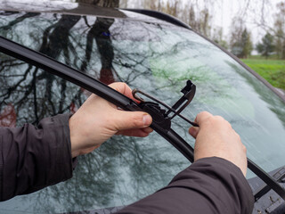 Replacement of car windshield wipers. Change cars wiper blades. Technician Man changing windshield wiper blades on car
