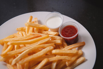 Closeup view of French fries with toppings served on a white plate.