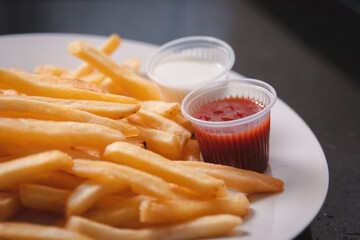 Detail view of French fries with different toppings served on a white plate.