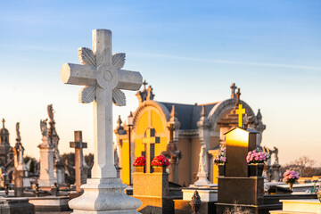 Catholic cross view in a cemetery at sunset