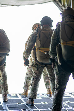 A group of soldiers are on a plane, one of them is wearing a backpack