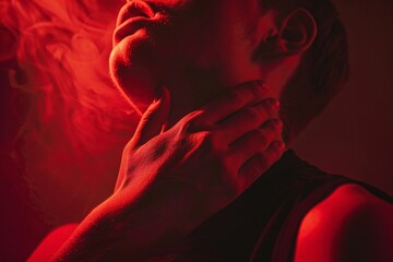 Close-up of a person clutching their chest in agony, warm red lighting, dramatic angle