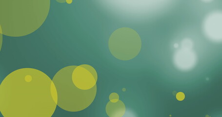 Image of yellow and white spots of light moving against green background