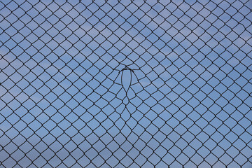 Looking up at a chain link fence with blue sky and clouds. wire fence. Chain link fence see sky....