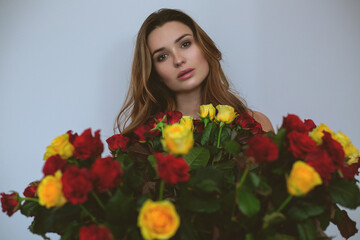 Beautiful young woman with bouquet of flowers
