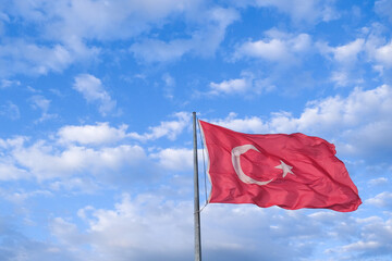 Turkish flag waving with cloudy sky background. Indepence day background for Turkey Türkiye. Open space area. Selective focused.