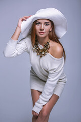 Beautiful woman in a white dress and hat