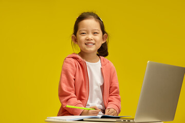  Cheerful Korean Toy with Bright Smile Engages in Learning sitting over isolated background. Sprightly Chinese Child Enjoys Study Time - 785534346