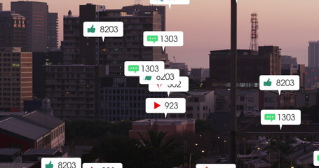 Image of social media icons falling against aerial view of cityscape