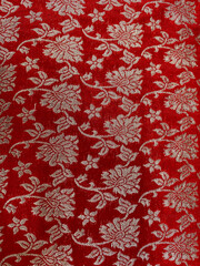 Intricate golden zari floral design woven on red silk fabric