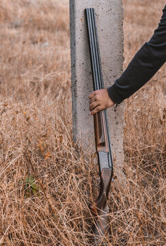double-barreled shotgun with cartridges, leaning against a pole. Hunting concept