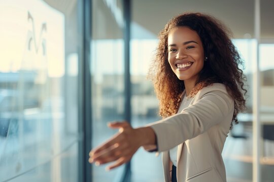 Radiant young woman extending a warm embrace in a bright modern office setting