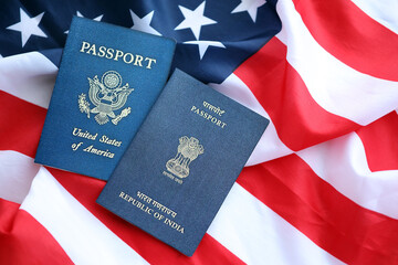 Passport of India with US Passport on United States of America folded flag close up