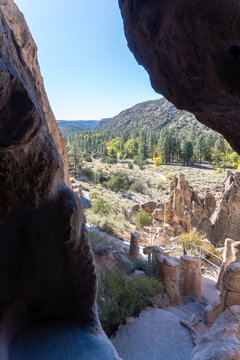 Bandelier National Monument preserves Ancestral Puebloan homes in New Mexico. View from Cavate dwelling in tuff cliff of Tuffs, Frijoles Canyon, Cottonwood trees in autumn, Pueblo loop trail.