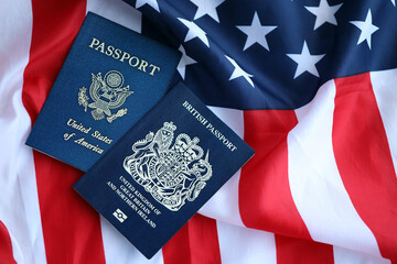 Passport of Great Britain with US Passport on United States of America folded flag close up