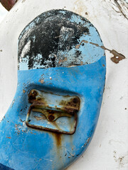 A blue and white object with a rusted metal handle