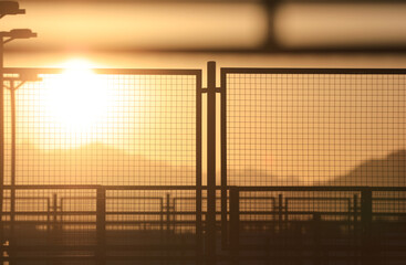 prison mesh fence at orange sunset
