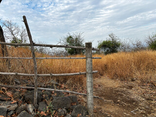 A wooden fence with a post in the middle of a field