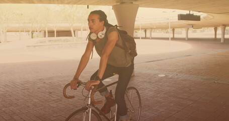 Image of biracial man cycling in city - Powered by Adobe