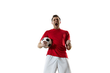 Motivated and emotional young man, football player in red uniform standing with ball and shouting...