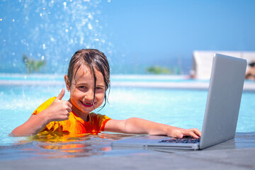 Distance Learning, learning and study everywhere and always. Young girl learning with laptop computer in the swimming pool.