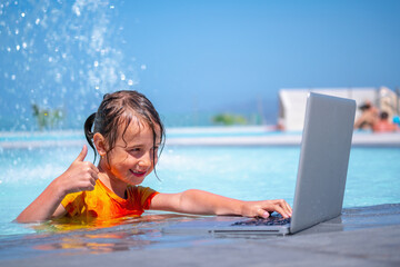 Distance Learningю Learning and study everywhere and always. Young girl learning with laptop computer in the swimming pool water.