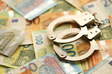 Many European euro money bills and handcuffs. Lot of banknotes of European union currency and cuffs...