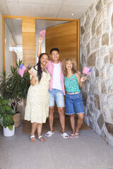 Group of friends waving American flags, standing at home entrance
