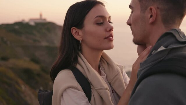 A serene scene with a young woman and her boyfriend sharing a loving gaze at sunset, evoking feelings of romance and connection.