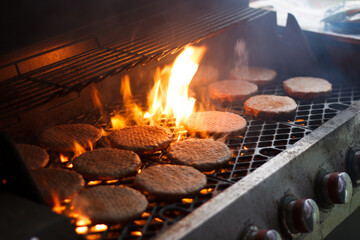 Flaming burgers on a grill