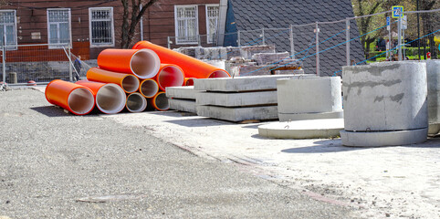 Materials for the repair of water pipes were collected on the square. Plastic large orange pipes,...
