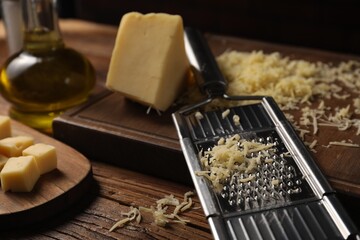 Different types of cheese and grater on wooden table, closeup