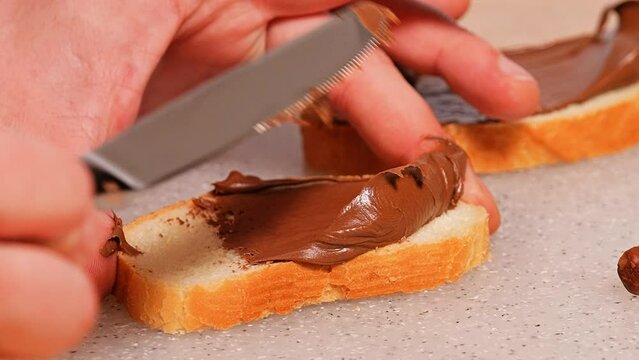 Breakfast. sandwich with nut butter. Hazelnuts on the table and chocolate spread on fresh bread