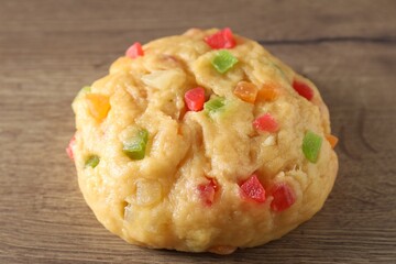 Raw dough with candied fruits on wooden table, closeup