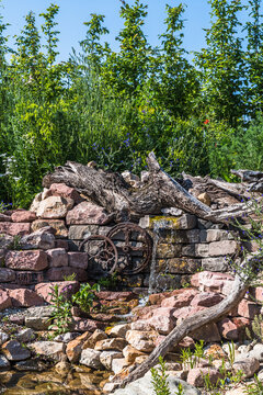 Natural garden with stones, old wood and watercourse