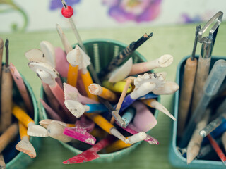 Tools of the ceramic artist. Top view of stacks, scallops, pencils and brushes which are located in...