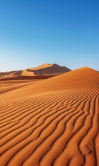 Fototapeta na wymiar A vast expanse of sand dunes in the desert's heart, backed by a crystal-clear blue sky