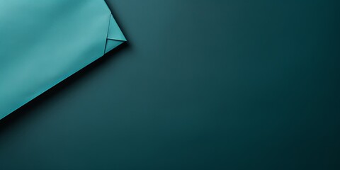 Teal background with dark teal paper on the right side, minimalistic background, copy space concept, top view