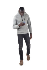 front view of a man walking and looking at smartphone on white background - 785571189