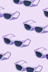 Pattern made of purple sunglass on purple background. Creative pattern.