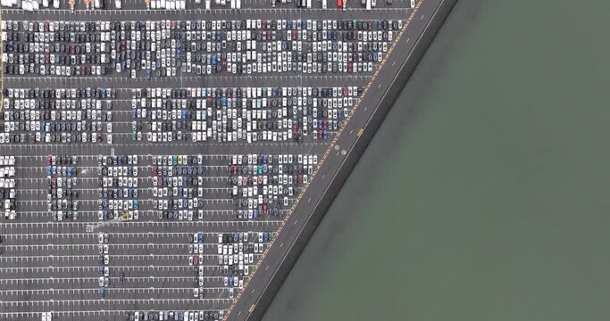 Aerial drone view on a roll on roll off terminal, filled with cars ready for intermodal transport, over seas, land and rails. Internaitonal trade and shipping logisitcs.
