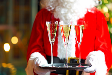 Santa Claus holding champagne glasses on the tray