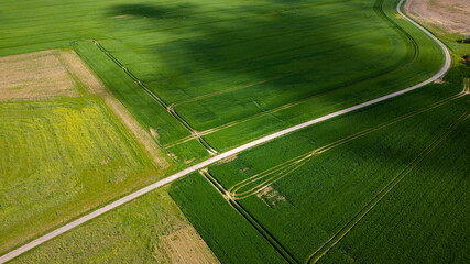 Prairie verte avec route sinueuse avec des traces géométriques au printemps vu de haut en drone en Normandie en France